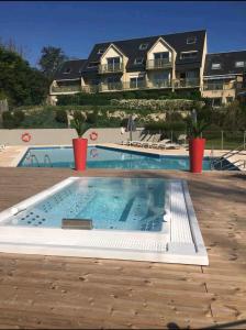 a large swimming pool in front of a house at Studio Golf piscine D Day in Port-en-Bessin-Huppain