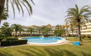 a resort with a swimming pool and palm trees at Las Terrazas - Apartamento en segunda línea Playa Cargador ALBERT VILLAS in Alcossebre