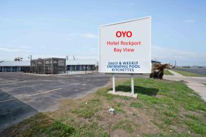 a sign in front of a parking lot at OYO Hotel Rockport- Bay View in Rockport