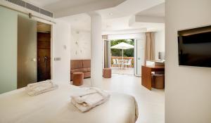 1 dormitorio con 1 cama con reloj en la pared en Apartamentos Azul Playa, en Cala d´Or