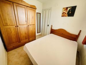 a bedroom with a bed and a wooden cabinet at A935 - La Cala in Villajoyosa