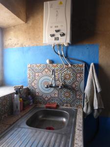 cocina con fregadero y dispensador de toallas de papel en Desert Backpackers hostel, en Merzouga