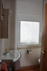 baño con lavabo y ventana en Ferienhaus Haus am Medebach, en Olsberg