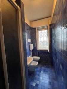 ein Bad mit einem WC, einem Waschbecken und einem Fenster in der Unterkunft Attico vista San Luca in Bologna
