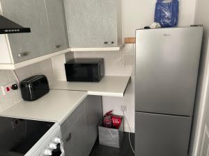 uma cozinha com um frigorífico e um micro-ondas em 3-Bed House in Stoke-on-Trent Free Sky Free Wifi em Stoke-on-Trent