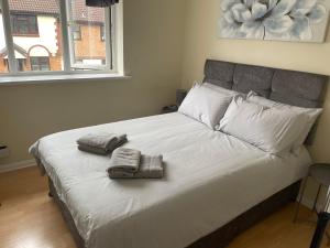 1 dormitorio con 1 cama con 2 toallas en 3-Bed House in Stoke-on-Trent Free Sky Free Wifi, en Stoke on Trent
