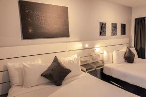 1 dormitorio con 2 camas y una pizarra en la pared en Up Midtown en Miami