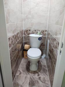 a bathroom with a toilet in a tiled room at Апартаменты в Хромтау. Энглер in Khromtaū
