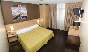 
a bedroom with a bed and a television at Hotel Moon in A Coruña
