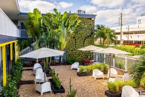 patio ze stołami, krzesłami i parasolami w obiekcie Up Midtown w Miami