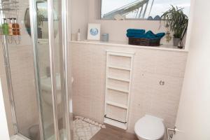 a bathroom with a toilet and a glass shower at Wild Sands Next to Beach ✩ Cinema ✩ Living Roof ✩ Games Room in Camber +23 photos