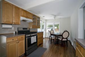 una cocina con armarios de madera y una mesa con sillas. en Hamptons Vacation Inn, en Hampton Bays