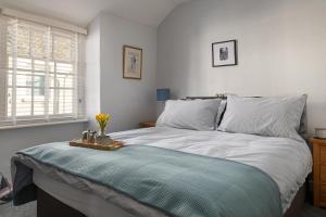 - une chambre avec un grand lit et une couverture bleue dans l'établissement Gull Cottage, à Conwy