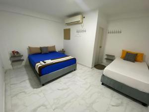 1 dormitorio con 2 camas y calentador. en Hotel Aventura Riohacha en Riohacha