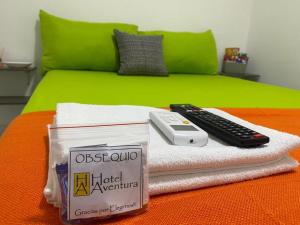 1 cama con mando a distancia encima de las toallas en Hotel Aventura Riohacha en Riohacha