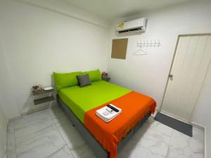 ein kleines Schlafzimmer mit einem grünen und orangefarbenen Bett in der Unterkunft Hotel Aventura Riohacha in Ríohacha