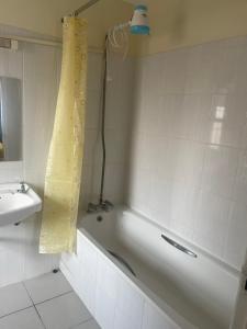Baño blanco con bañera y lavamanos en Inviting 3-Bed Apartment in Nairobi en Nairobi