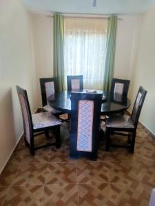comedor con mesa negra y sillas en Inviting 3-Bed Apartment in Nairobi en Nairobi