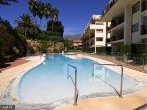 uma grande piscina ao lado de um edifício em Mijas Golf penthouse em Santa Fe de los Boliches