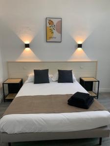a bedroom with a large bed with two lights on it at Hôtel Restaurant de l'Union in Mirambeau +20 photos