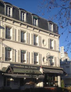 un gran edificio blanco con un cartel. en L'Auberge des 3 Marches, en Le Vésinet