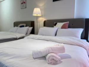 a white bed with a towel on top of it at Infistay Homestay - Sunway Geo Avenue, Sunway Pyramid, Sunway Lagoon, Sunway University, Sunway Medical Centre in Subang Jaya