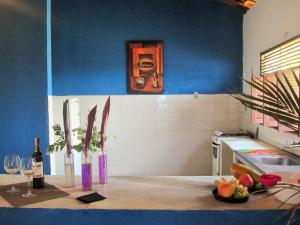 Natal Casa de Playa en Pitangui‏ في Pitangui: مطبخ بجدران زرقاء وكاونتر مع كؤوس للنبيذ