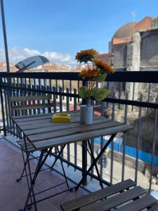 una mesa de madera con flores en el balcón en Il Girasole, en Catania