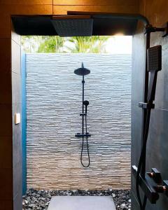 a shower in a bathroom with a wall at CASA FERDI 1, logement entier avec piscine privée in Le Marin