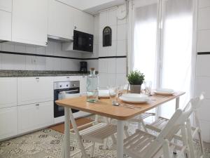 une cuisine avec une table en bois et 2 chaises dans l'établissement Apartamento La Zurri near Kursaal, à Saint-Sébastien