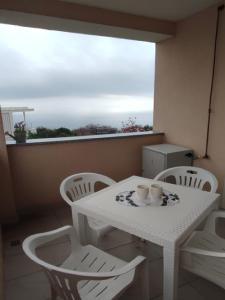 a white table and chairs in a room with a window at Apartments Baricevic in Opatija