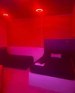 リオアチャにあるHotel la Sierra Riohacha Iの赤いライト付きのベッドが備わる客室です。