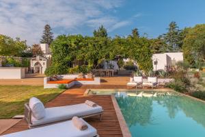 a backyard with a pool and chairs and a house at Dimora Dei Semplici in Ostuni