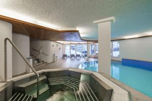 een zwembad in een gebouw met een zwembad bij Hotel Alpenroyal in Zermatt