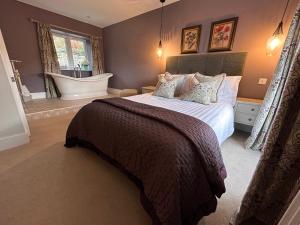 a bedroom with a bed with a bathtub and a bath tub at The Cottage in Dunblane