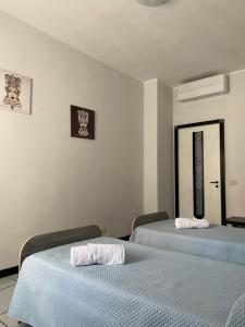 dos camas sentadas una al lado de la otra en una habitación en Il Girasole, en Catania