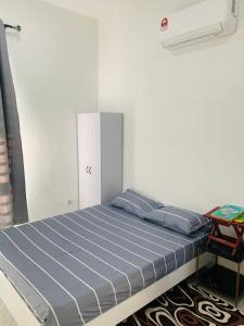 a bed in a room with a white wall at Bonda Homestay Selama - Musllim Only in Selama