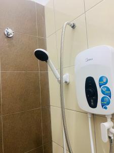 a shower head and a phone in a bathroom at Bonda Homestay Selama - Musllim Only in Selama