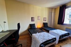 una stanza con due letti, un tavolo e una scrivania di #EX Le Vercors T3 for 4 close to GEM and train station a Grenoble