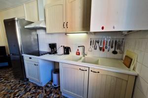 una cucina con mobili bianchi, un lavello e un frigorifero di #EX Le Vercors T3 for 4 close to GEM and train station a Grenoble Altre 6 foto