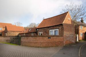 a brick house with a red roof on a street at The Coffin Maker's Cottage, Bunny in West Leake