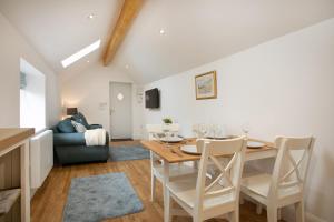 a dining room and living room with a table and chairs at The Coffin Maker's Cottage, Bunny in West Leake