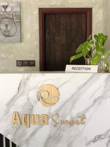 un comptoir en marbre blanc avec un panneau indiquant le coucher de soleil aza dans l'établissement Aqua Sunset, à Gulhi