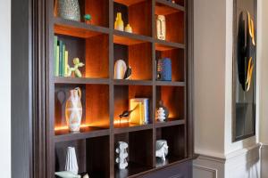 a wooden book shelf with vases and books at voco Edinburgh - Royal Terrace, an IHG Hotel in Edinburgh