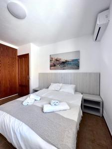 a bedroom with a white bed with towels on it at VILLA BLANCA in Cala Ferrera +49 photos