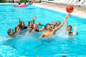 eine Gruppe von Menschen in einem Pool mit Basketball in der Unterkunft Gattarella Family Resort - Standard Half-Board à buffet in Vieste