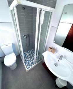 a bathroom with a shower and a toilet and a sink at VILLA BLANCA in Cala Ferrera
