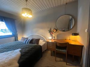 a bedroom with a bed and a desk and a mirror at Drømmefabrikken in Bleik