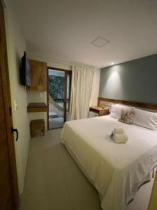 Un dormitorio con una gran cama blanca y una ventana en Terra Bella Pousada, en Morro de São Paulo
