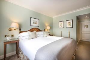 - une chambre avec un grand lit blanc et deux lampes dans l'établissement The Capital Hotel, Apartments & Townhouse, à Londres